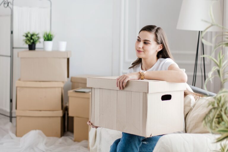 A young woman is happy with her move to Coulsdon; surrounded by cardboard boxes in her new home