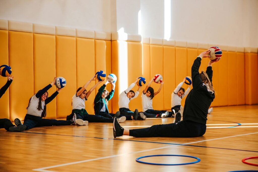 A teacher and students warming up for a volleyball