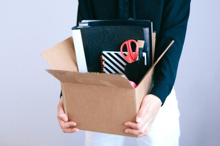 Cropped image of an employee holding a carton with office supplies in the concept of 'benefits of hiring a professional office removal service'.